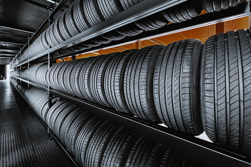 Tires lined up on a tire rack in an automotive shop